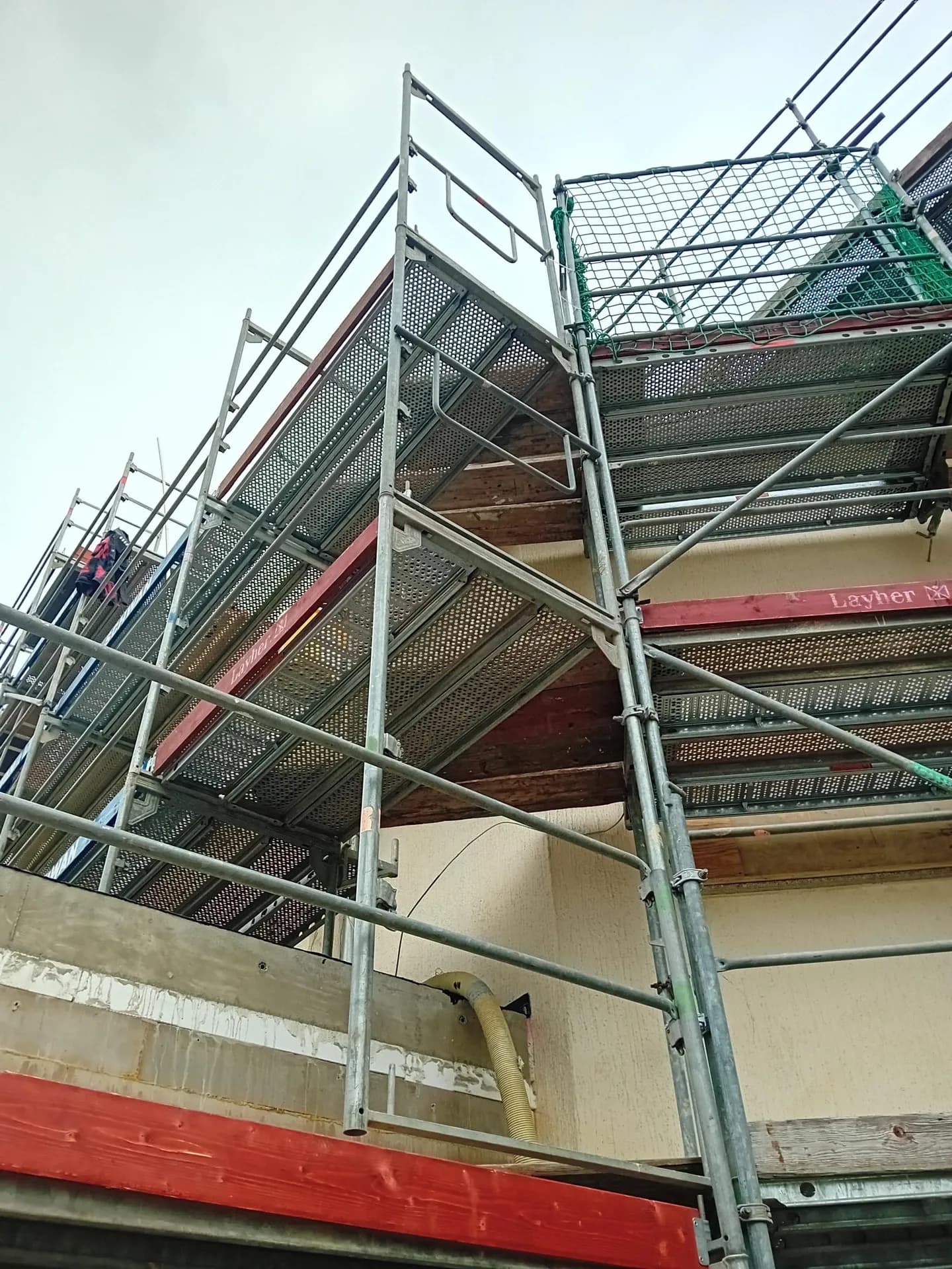 Blick von unten in das Fassadengerüst mit Durchstiegsböden und Schutznetz, Bibliothek Gardelegen