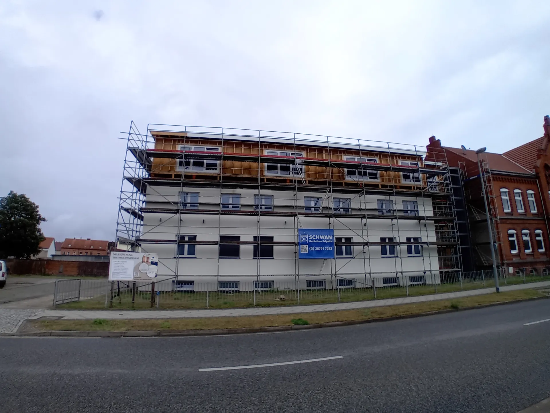 Komplett eingerüstete Straßenfront im ersten Bauabschnitt mit SCHWAN-Banner, Kinderheim Wittenberge