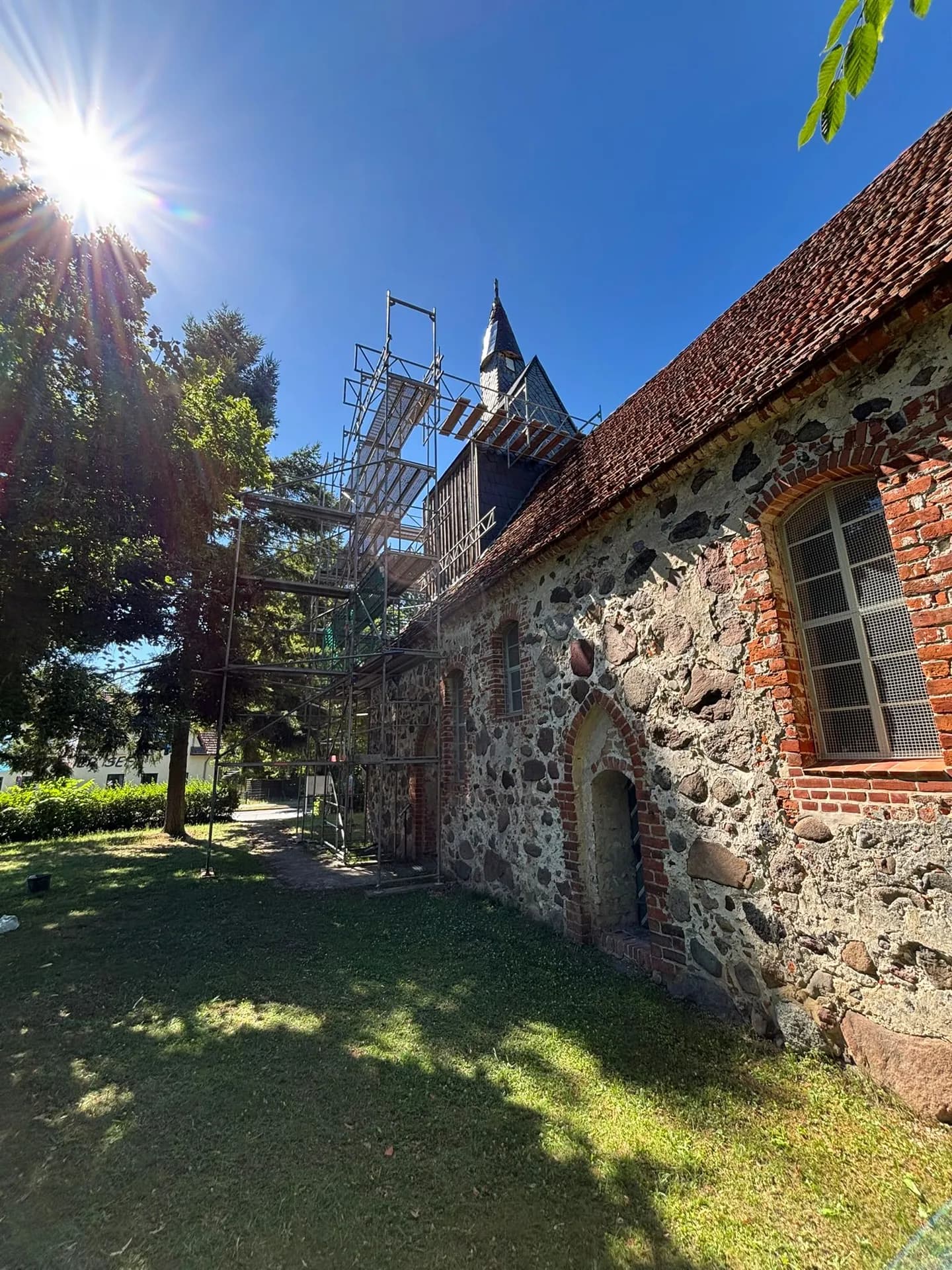 Fassadengerüst am Westturm der Feldsteinkirche Gnewikow mit auskragenden Arbeitsebenen