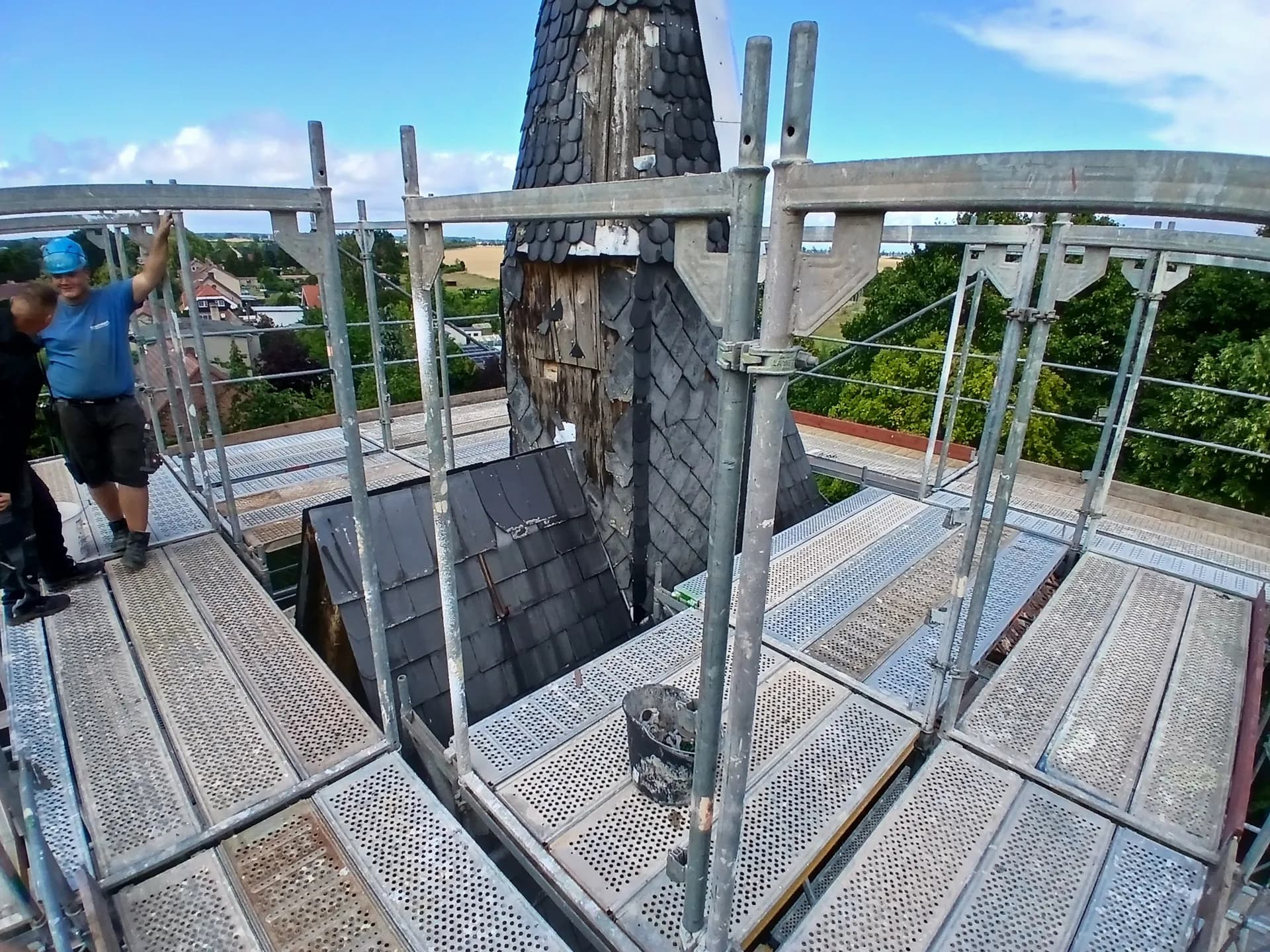Gerüstbauer auf der obersten Plattform des Raumgerüsts an der Kirchturmspitze, Dorfkirche Gnewikow
