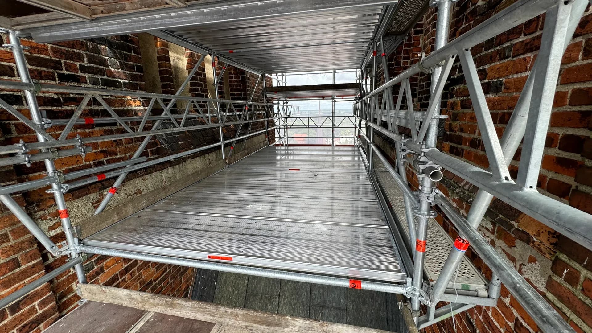 Gerüstebene mit Aluminium-Belägen und Gitterträgern in einer Turmöffnung der Marienkirche Stendal