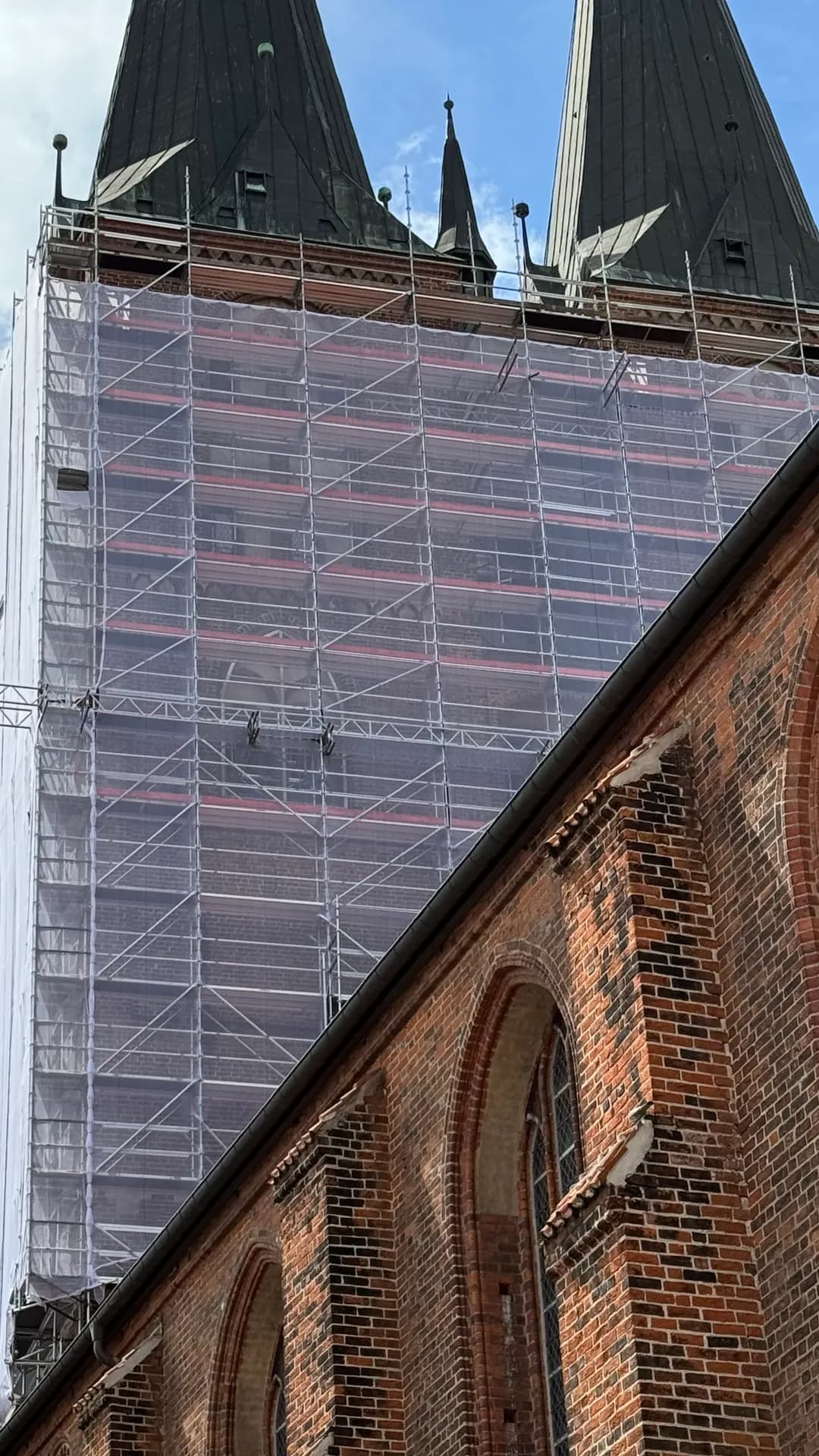 Abgenetztes Turmgerüst zwischen den Turmspitzen der Marienkirche Stendal bei blauem Himmel