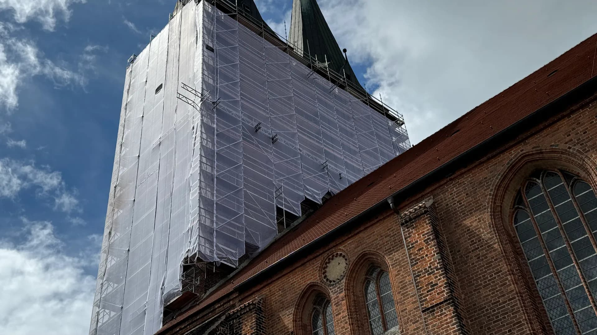 Komplett abgenetztes Turmgerüst an der Marienkirche Stendal über dem Dach des Kirchenschiffs, SCHWAN Gerüstbau 2024
